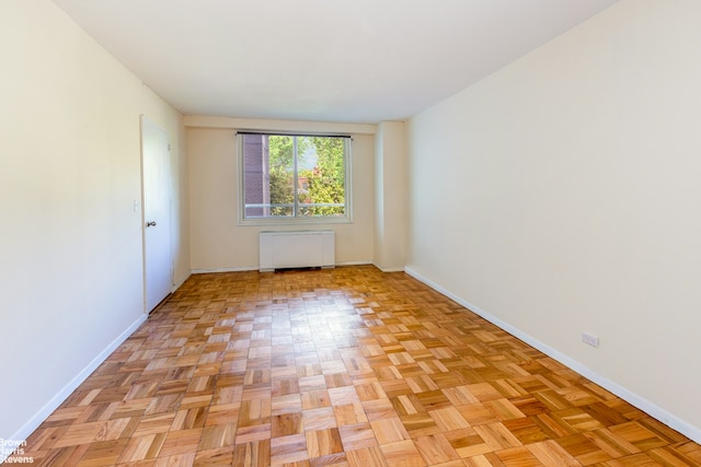 empty room featuring radiator heating unit and baseboards