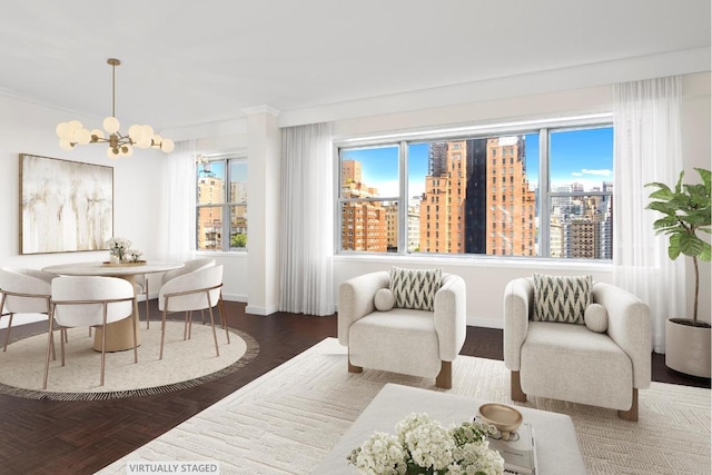 living area featuring baseboards, a view of city, a chandelier, and crown molding