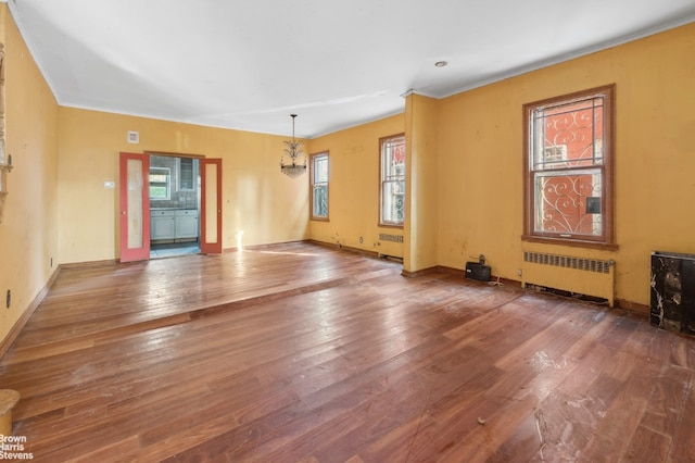 spare room featuring radiator and hardwood / wood-style flooring