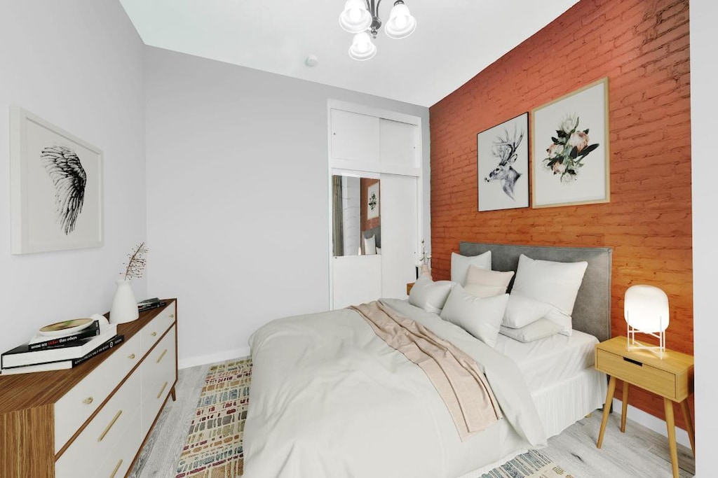 bedroom featuring light wood-type flooring and a chandelier