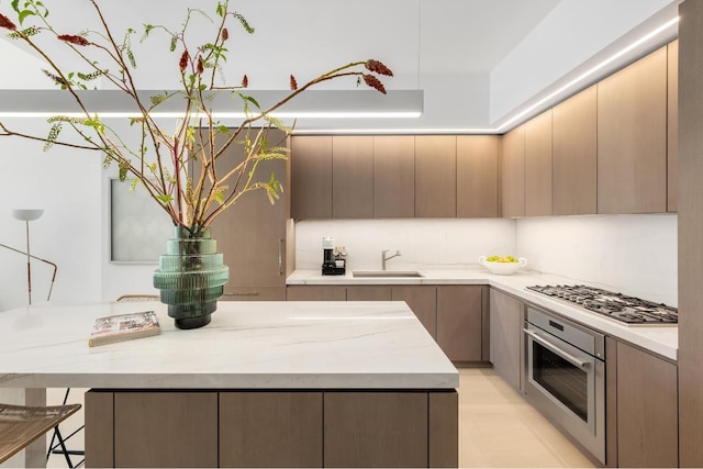 kitchen featuring light stone countertops, appliances with stainless steel finishes, and sink