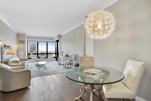 dining area with wood finished floors, visible vents, ornamental molding, a city view, and a notable chandelier