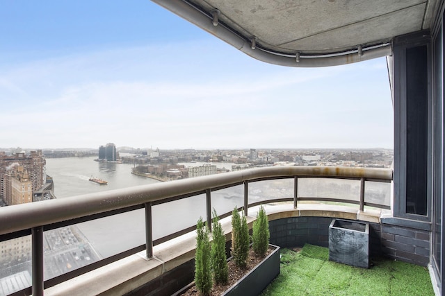 balcony featuring a water view and a city view