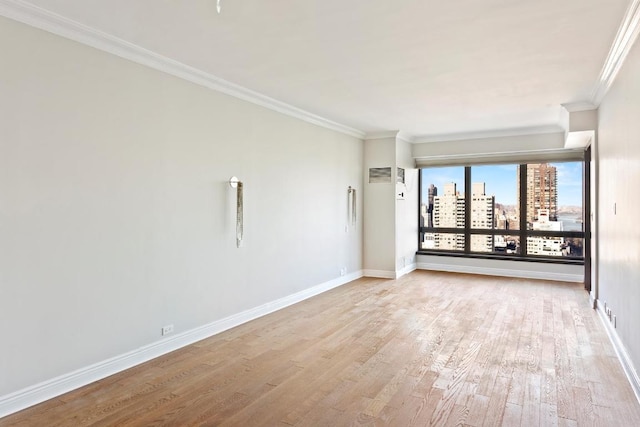 spare room with crown molding and light hardwood / wood-style flooring