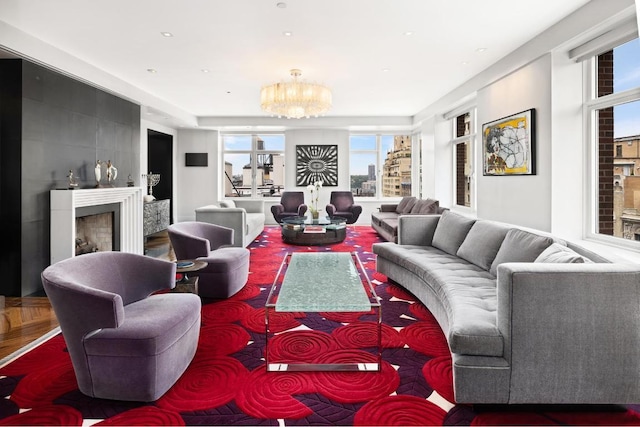 living room with parquet flooring, a large fireplace, and a chandelier