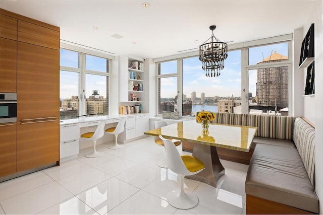 sunroom with breakfast area, built in desk, and an inviting chandelier