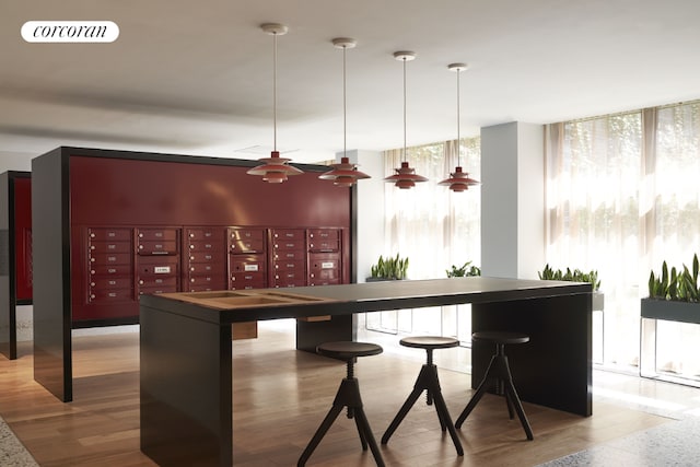 bar with pendant lighting, wood-type flooring, a wall of windows, and mail boxes