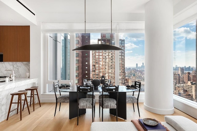 dining area with a wealth of natural light and light hardwood / wood-style flooring