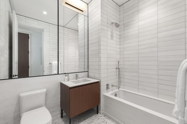 full bathroom featuring toilet, vanity, tile walls, tile patterned flooring, and shower / tub combination