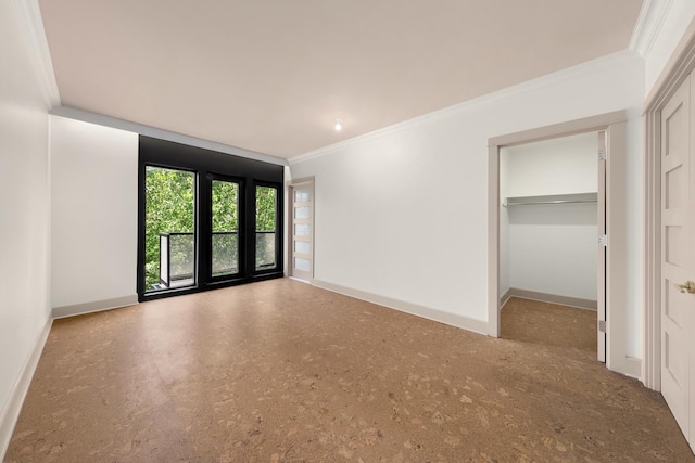 interior space with baseboards, ornamental molding, and a spacious closet