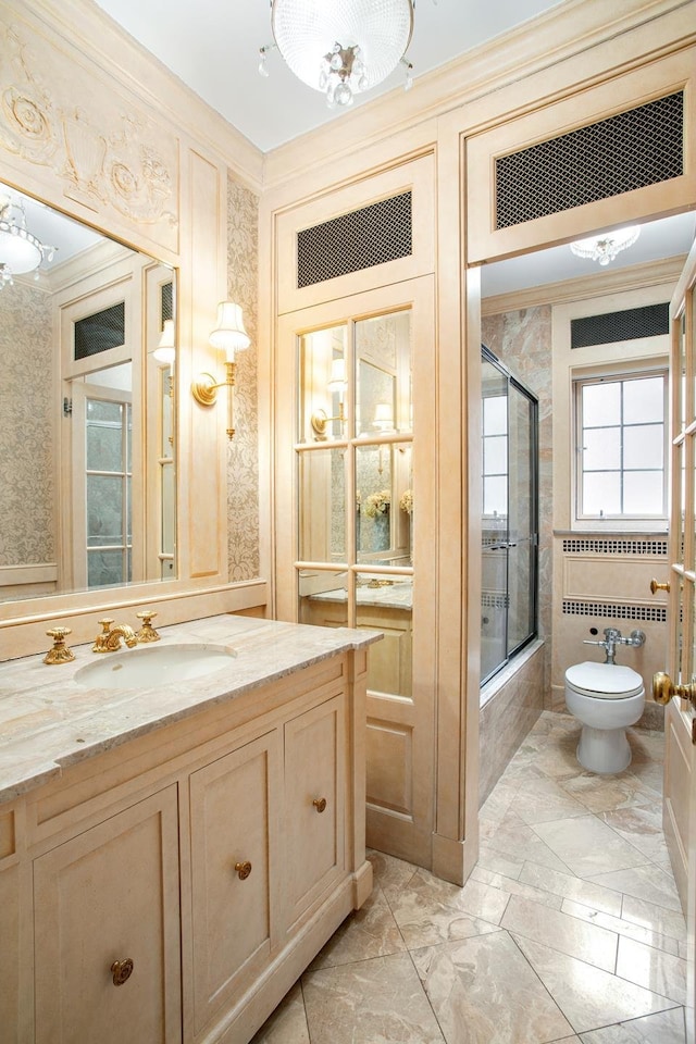 bathroom featuring vanity, crown molding, toilet, and enclosed tub / shower combo