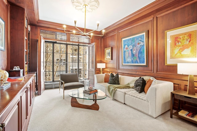 living area with wood walls, light colored carpet, crown molding, and a notable chandelier