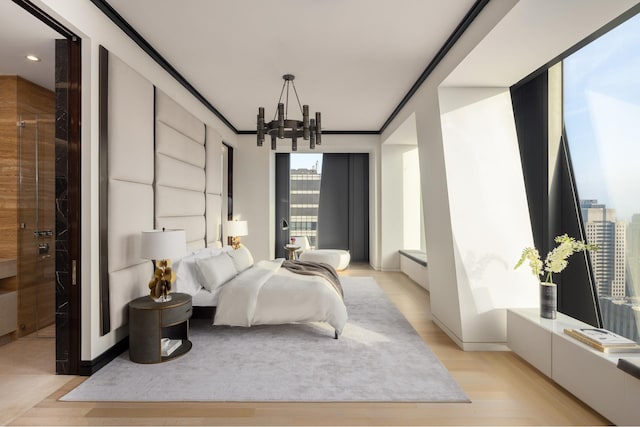 bedroom featuring light wood-style floors, ornamental molding, and a notable chandelier