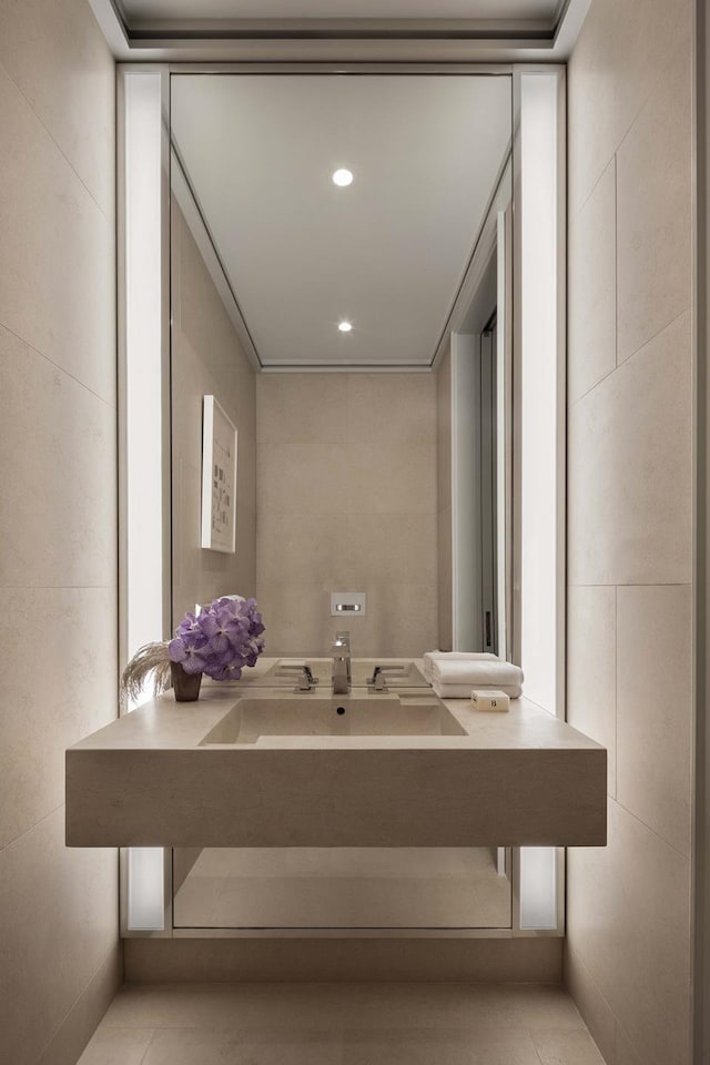 bathroom featuring a sink, tile walls, and recessed lighting