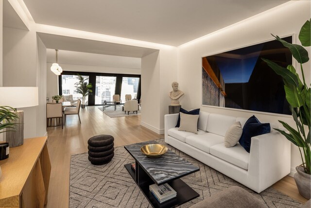 living room with a notable chandelier and light hardwood / wood-style flooring