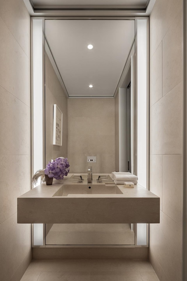 bathroom with recessed lighting, a sink, and tile walls