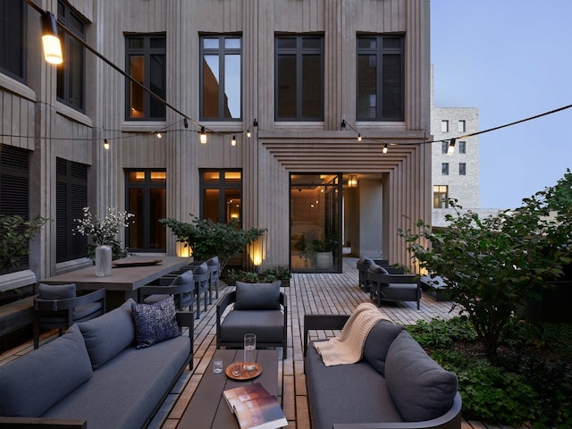 patio terrace at dusk with an outdoor living space and a wooden deck