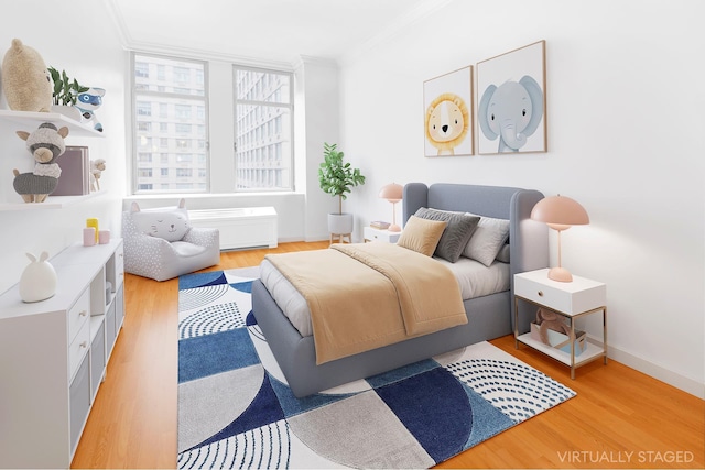 bedroom featuring baseboards, light wood-type flooring, and ornamental molding