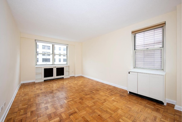 unfurnished room with light parquet floors and a textured ceiling