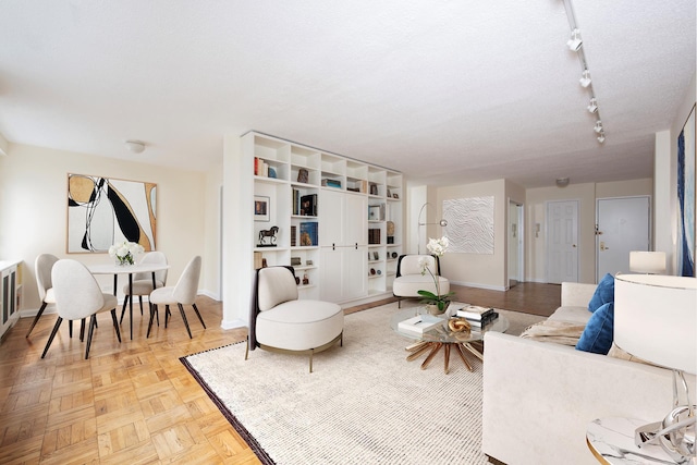 living area featuring track lighting and baseboards