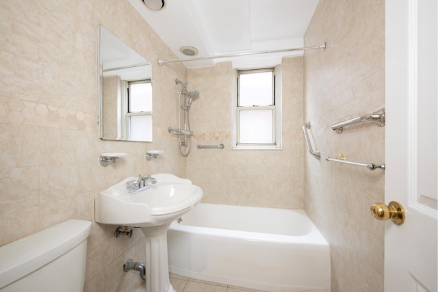 full bath with toilet, tile walls, and shower / tub combination