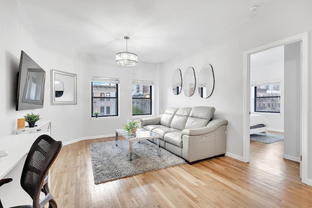 living room with a notable chandelier and light wood-type flooring