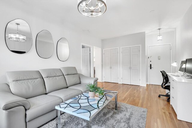 living room featuring light hardwood / wood-style flooring and an inviting chandelier