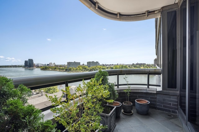 balcony featuring a water view and a city view