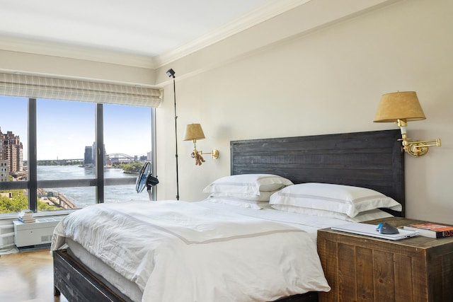 bedroom with ornamental molding, wood finished floors, and a city view