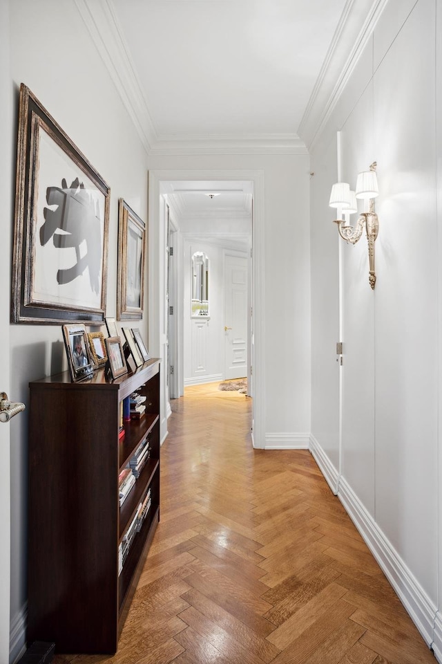 hallway featuring a notable chandelier, baseboards, and crown molding