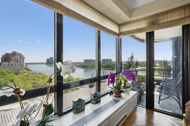 sunroom with a view of city and a water view