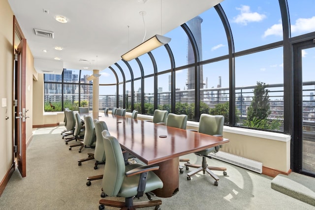 carpeted home office featuring baseboards, visible vents, baseboard heating, and a city view