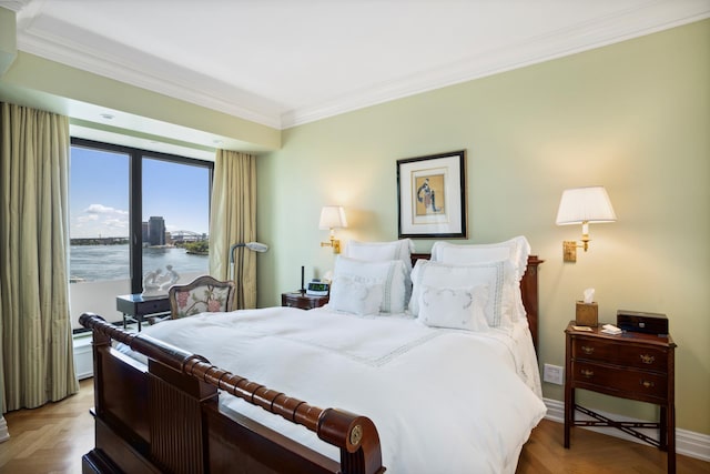 bedroom featuring a water view, crown molding, and baseboards