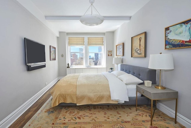 bedroom featuring wood-type flooring and beamed ceiling