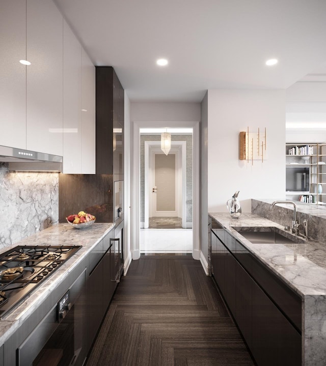 kitchen featuring white cabinets, light stone counters, modern cabinets, and a sink