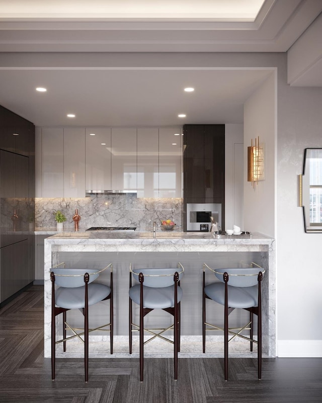 kitchen featuring a kitchen breakfast bar, backsplash, and modern cabinets