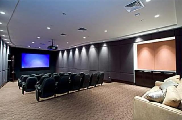 carpeted home theater room featuring recessed lighting, visible vents, and a decorative wall