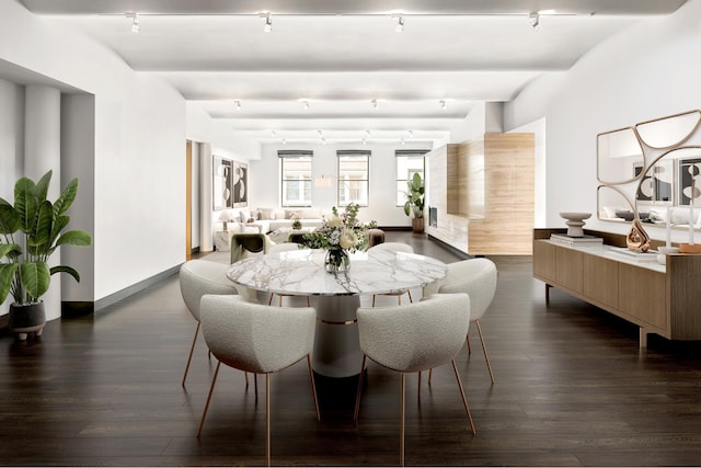 dining space with dark wood-type flooring, beamed ceiling, and baseboards