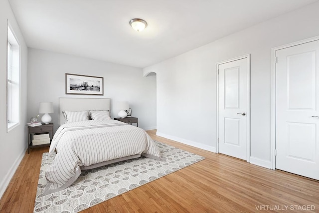 bedroom with multiple windows and wood-type flooring