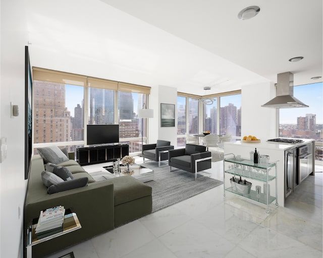 living area featuring expansive windows, marble finish floor, and a healthy amount of sunlight