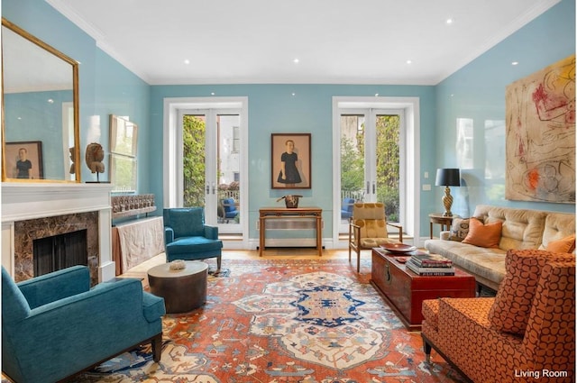 sitting room featuring wood-type flooring, a premium fireplace, ornamental molding, and french doors