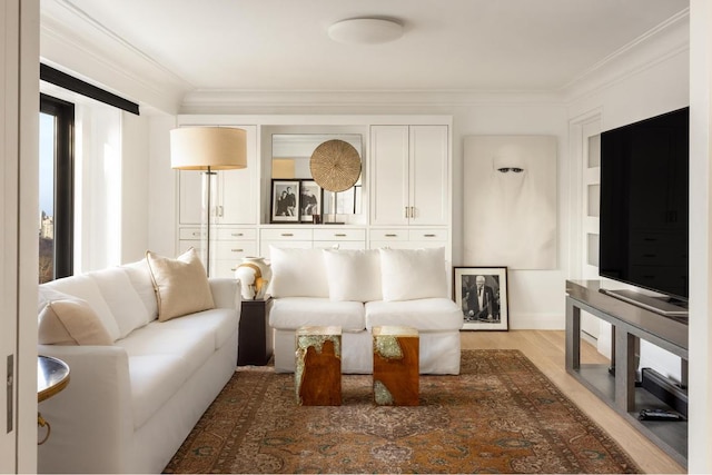 living room featuring light hardwood / wood-style flooring, crown molding, and a wealth of natural light