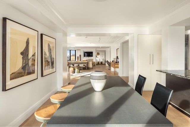 dining area with crown molding and light hardwood / wood-style flooring