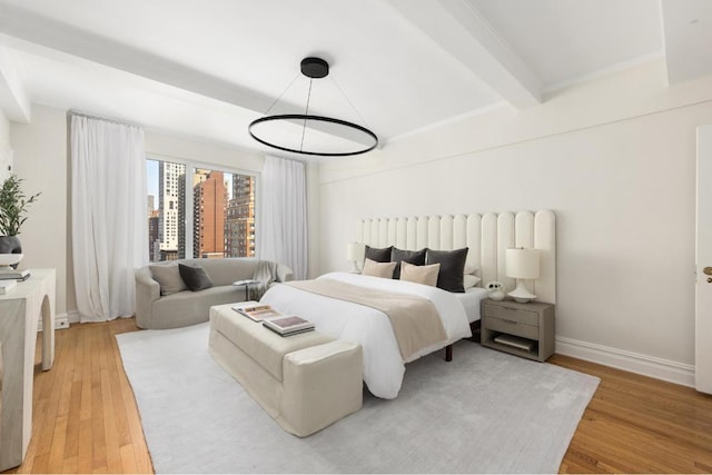 bedroom featuring beamed ceiling and hardwood / wood-style floors