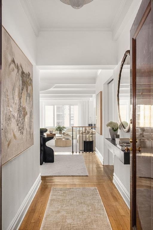 corridor featuring ornamental molding and hardwood / wood-style floors