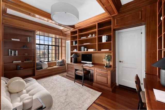 office area featuring wood walls, built in desk, built in features, and dark hardwood / wood-style floors