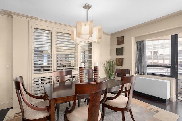 dining area featuring crown molding, baseboards, and wood finished floors