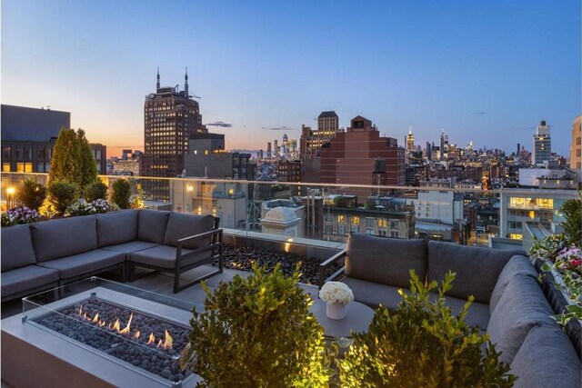 patio terrace at dusk featuring exterior kitchen, a grill, and a pergola