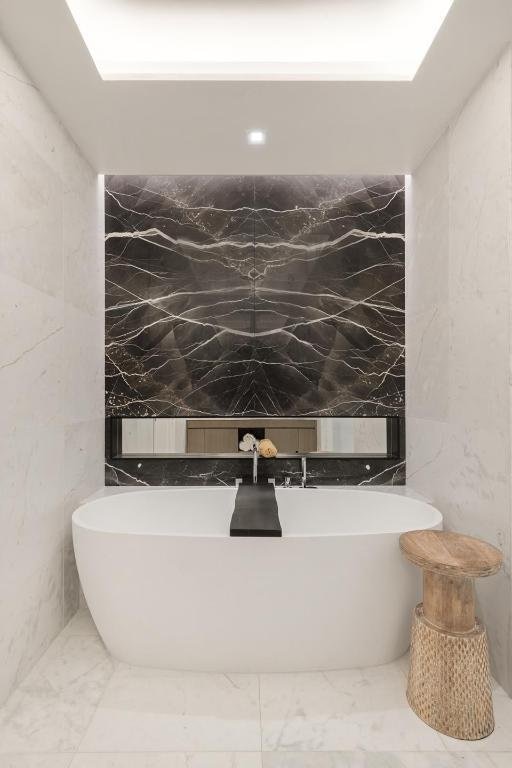 bathroom with tile walls and a tub to relax in