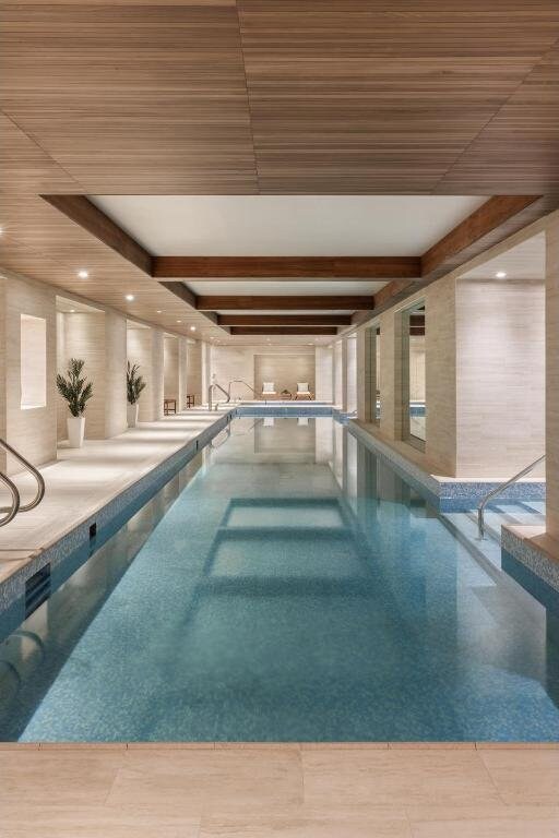 workout area with a tray ceiling and light hardwood / wood-style floors